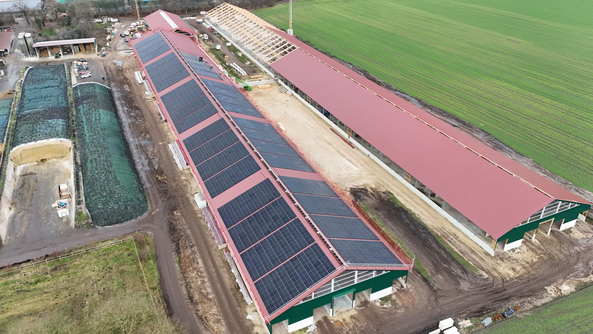 Schrägluftaufnahme der fertig bestückten Haupthalle mit rotem Trapezdach und vollständiger Modulbelegung